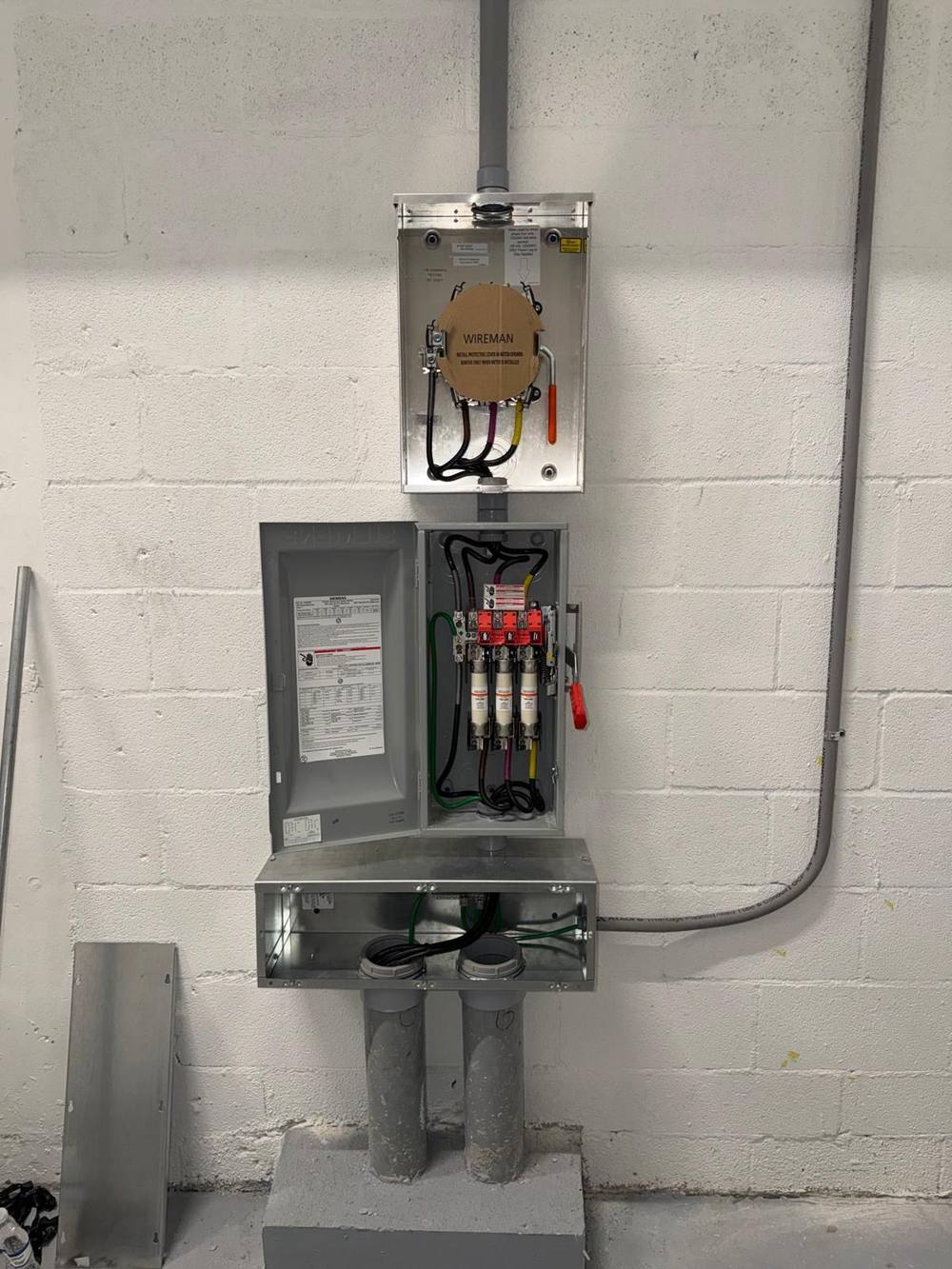 Meter can, fused disconnect, and junction box on painted block wall